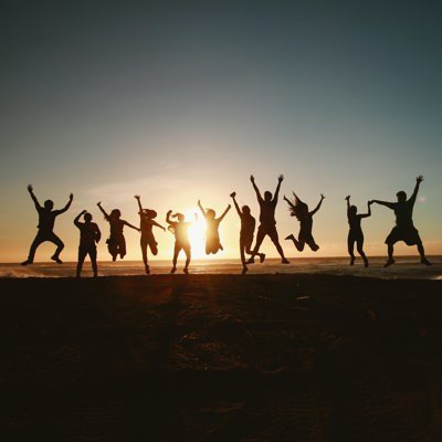 A group of people jumping in the sunset